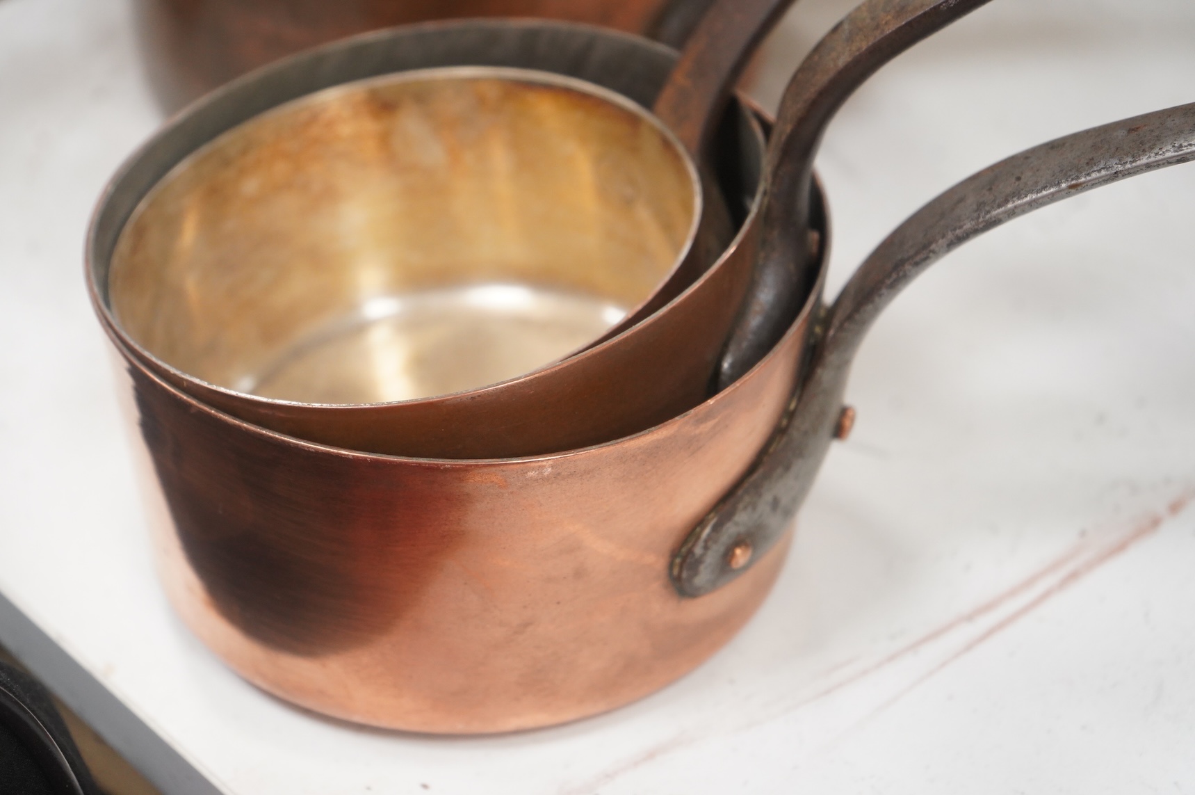 A graduated set of 4 saucepans and a hanging rack- 70 cm wide